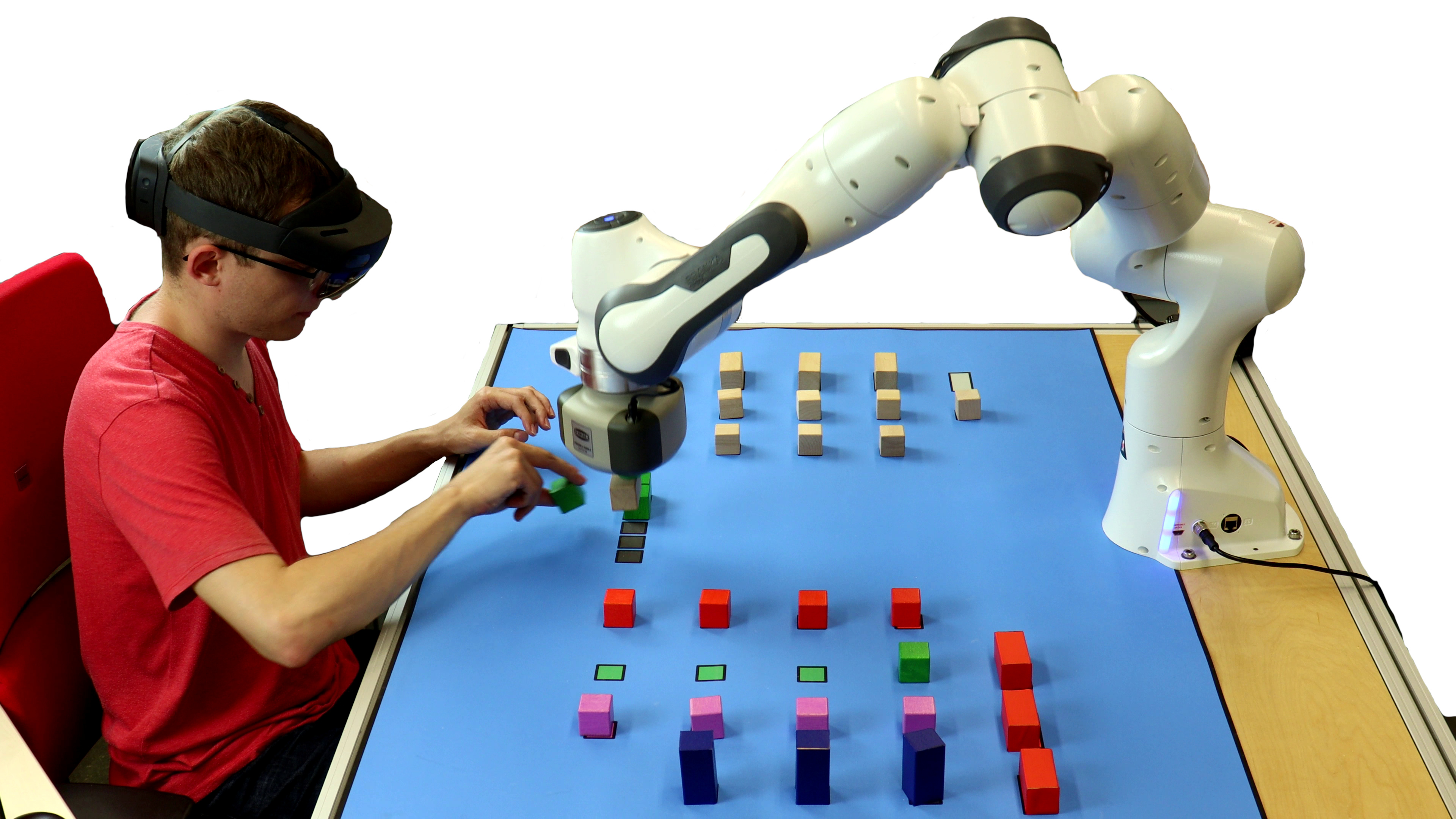 Human and robot cooperatively construct structure of building blocks.